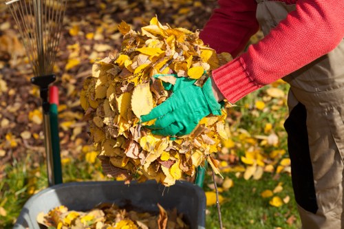 A local team removing green waste from a narrow London property access route